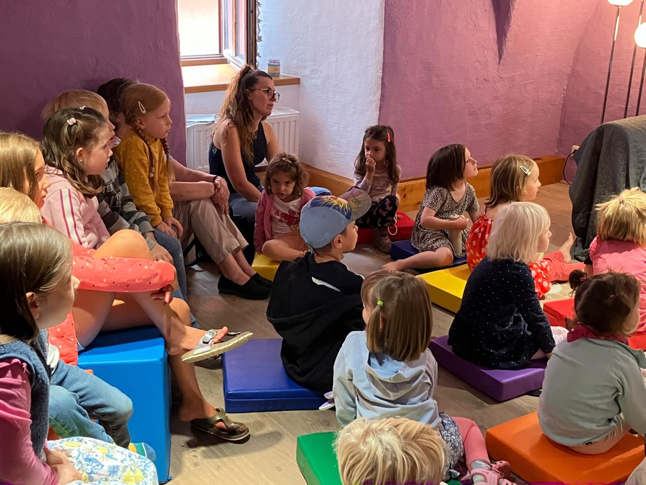 Kinder, die am Boden sitzen und zuhören