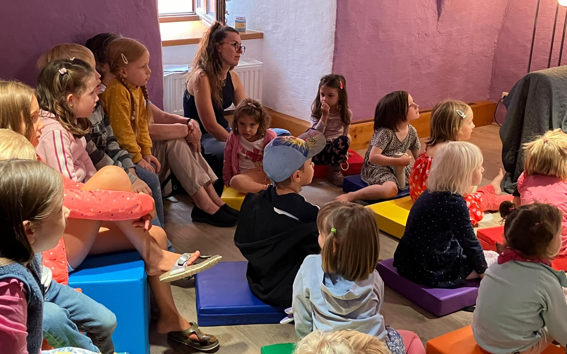 Kinder, die am Boden sitzen und zuhören
