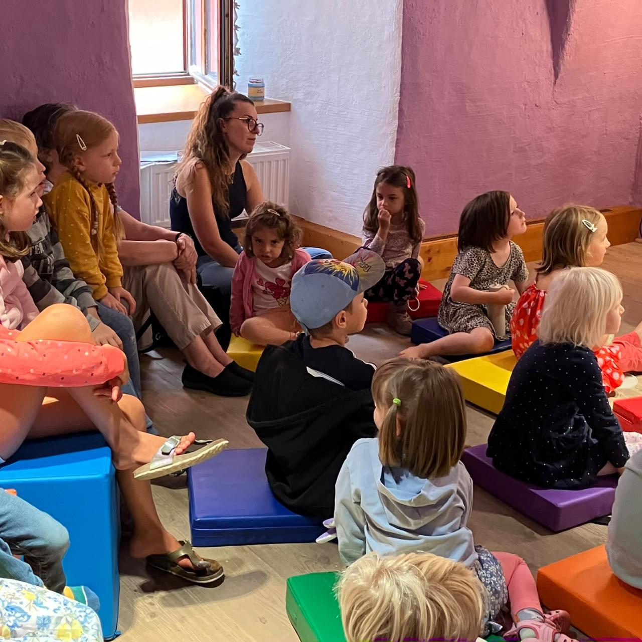 Kinder, die am Boden sitzen und zuhören